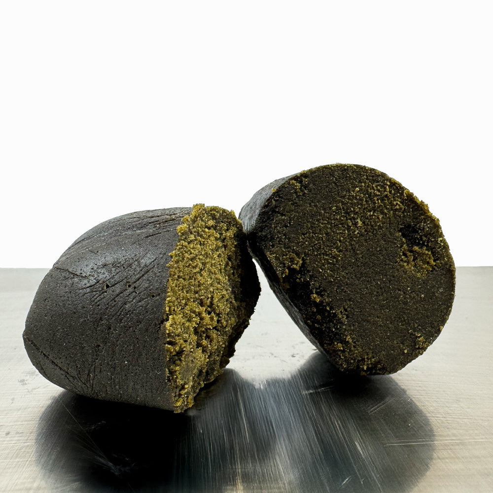 Boule de CBD Black Butter coupée en deux sur fond blanc